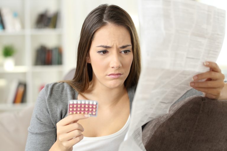 concerned woman reading pill leaflet